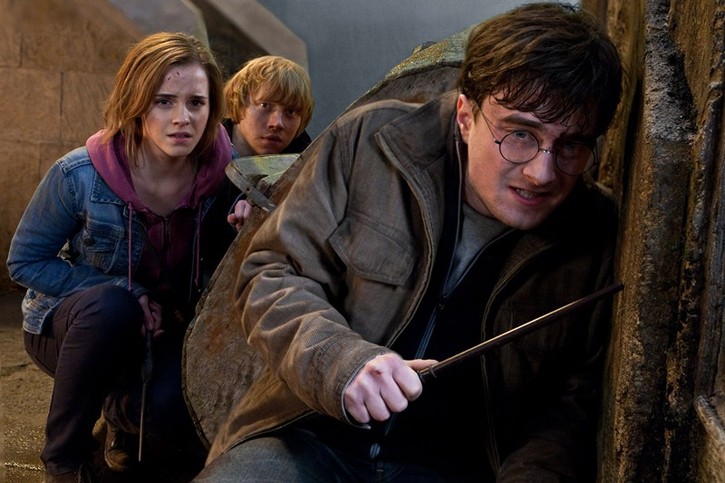 Harry Potter, Ron Wesleay et Ermione se protégeant derrière un mur